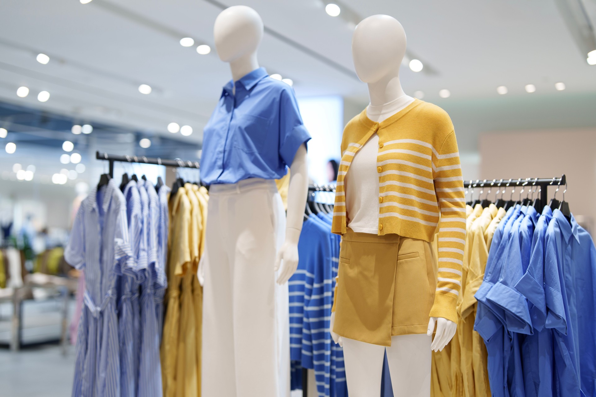 A cropped shot of women's clothing elegantly displayed on mannequins in a boutique.
