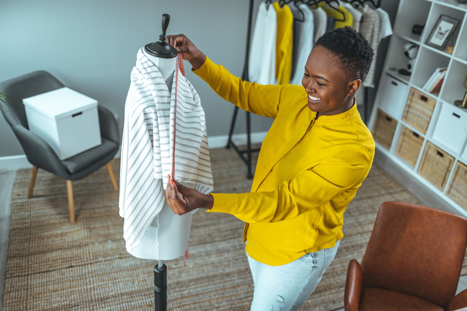 Tailor adjusts garment design on mannequin in workshop